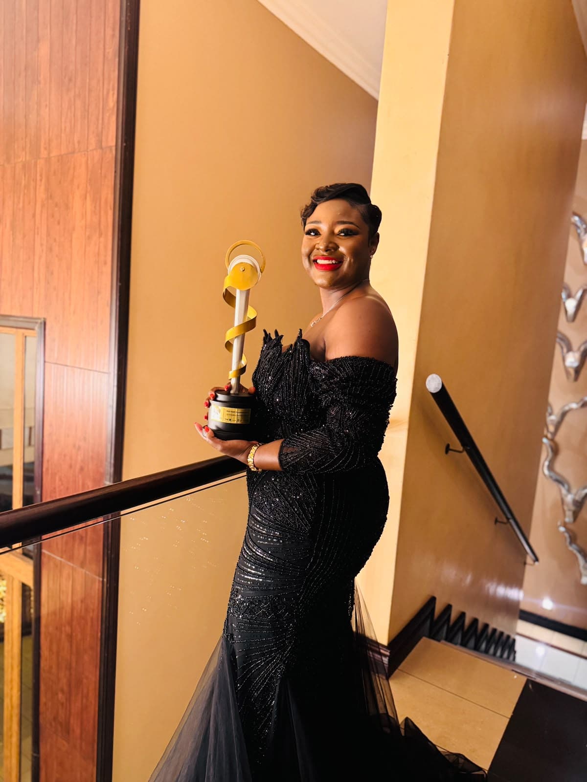 Dr Kholofelo Machaba-Selatole holding the Oral Health Excellence Award trophy at the ceremony venue